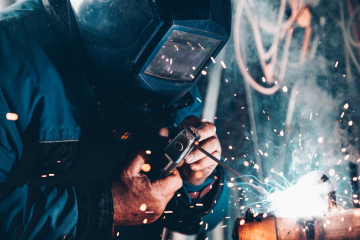 person welding, with a face shield on