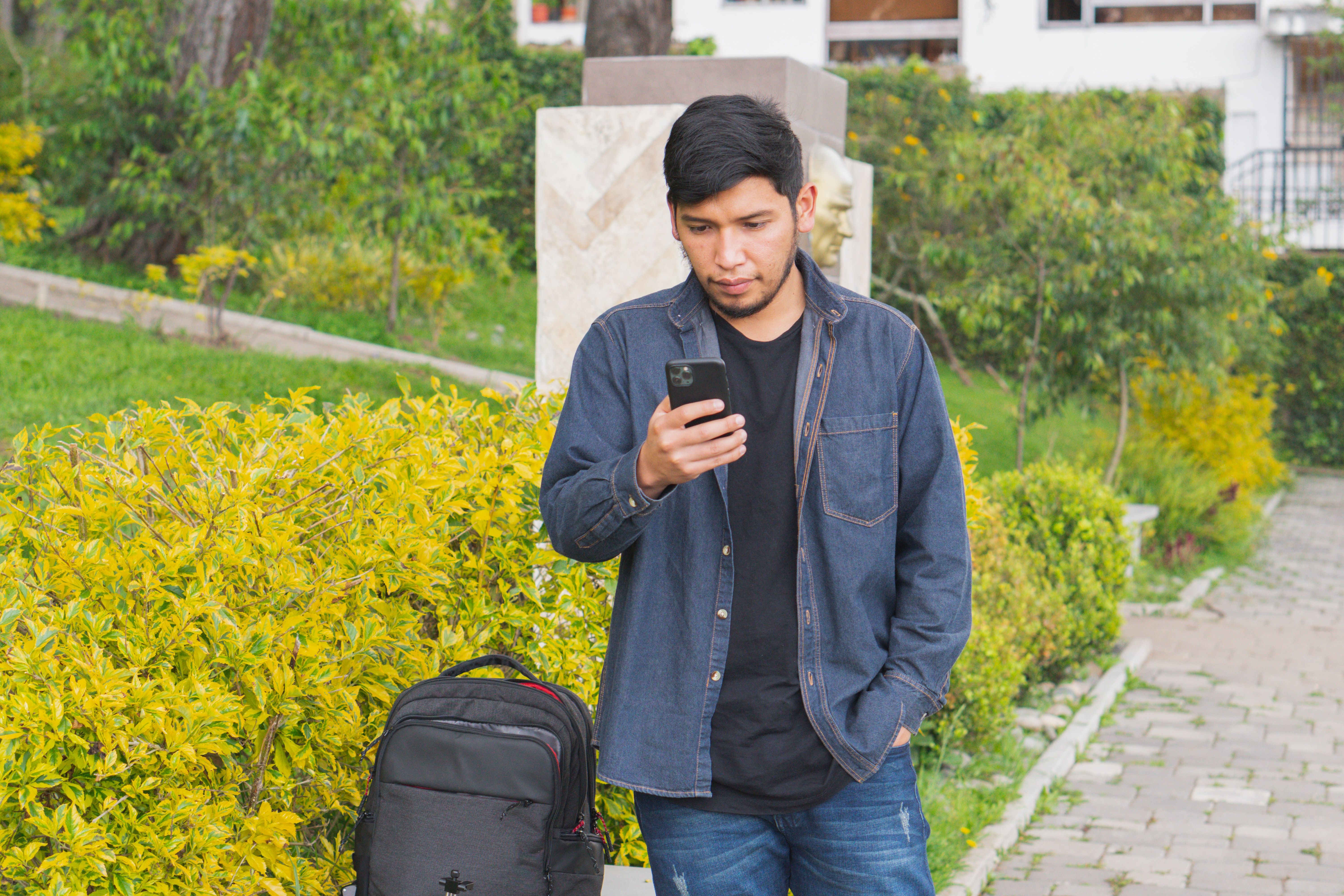 a person walking on the sidewalk with a focus on their cell phone