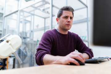 person sitting at a desktop computer with good posture