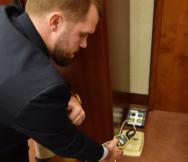 a person inspecting an electrical panel